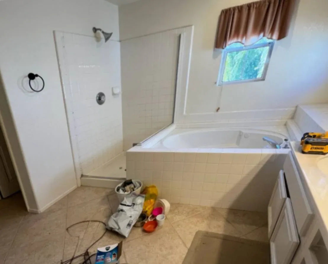 Dated San Diego primary bathroom before remodeling, with a built-in tub and old tile