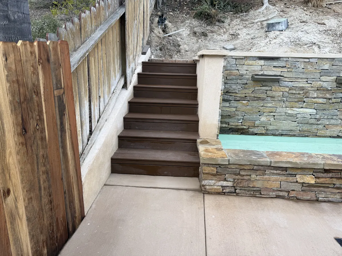Composite steps up the side yard next to the stacked-stone water feature