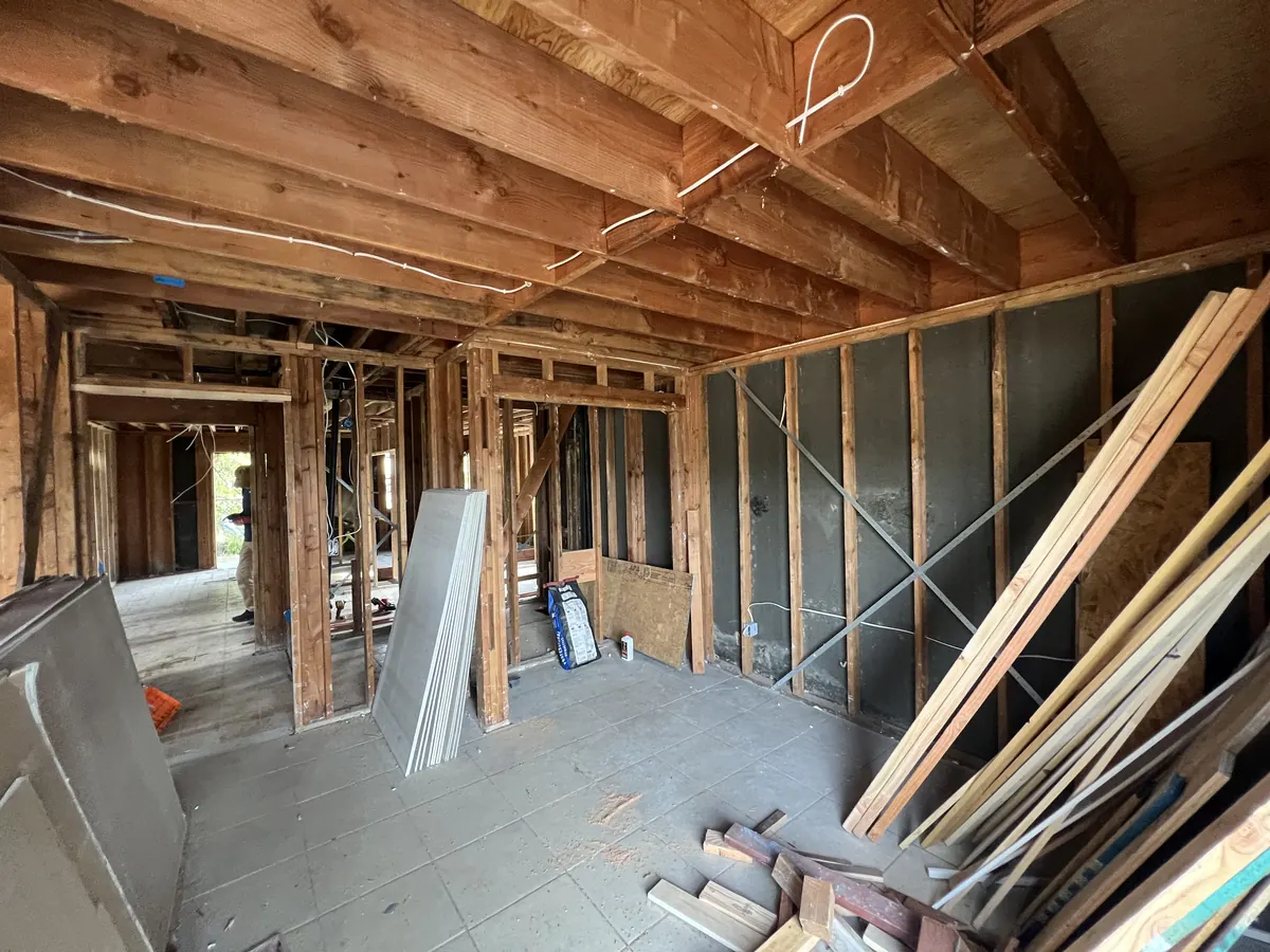 Ground floor opened to the framing during the rebuild, with new lumber stacked for reframing