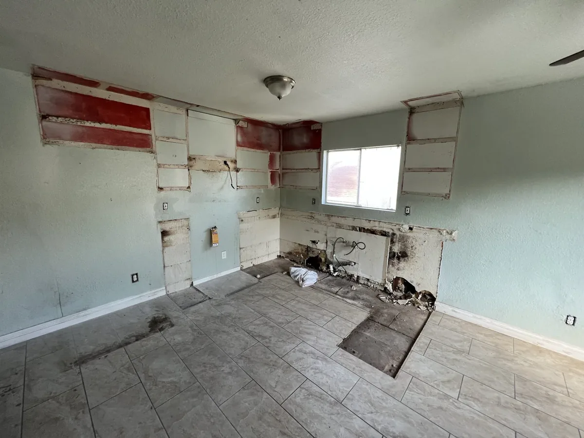 San Diego kitchen part way through demolition, with cabinets removed and services exposed