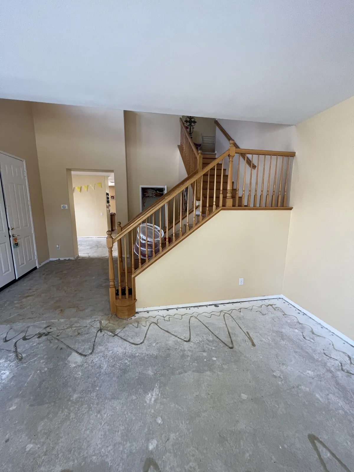 Oak staircase and bare concrete floor before the new stair treads and flooring