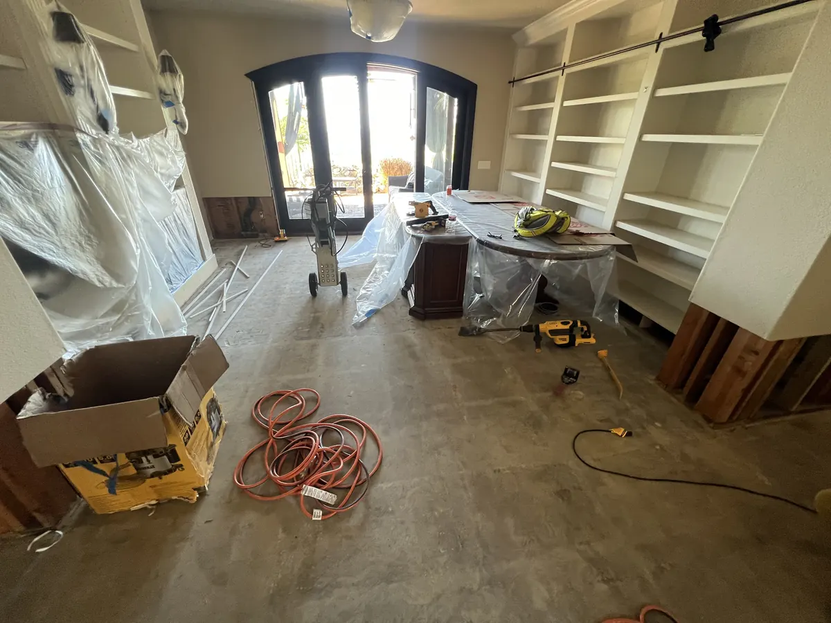 Living area with the old flooring removed and built-ins wrapped, before the new hardwood