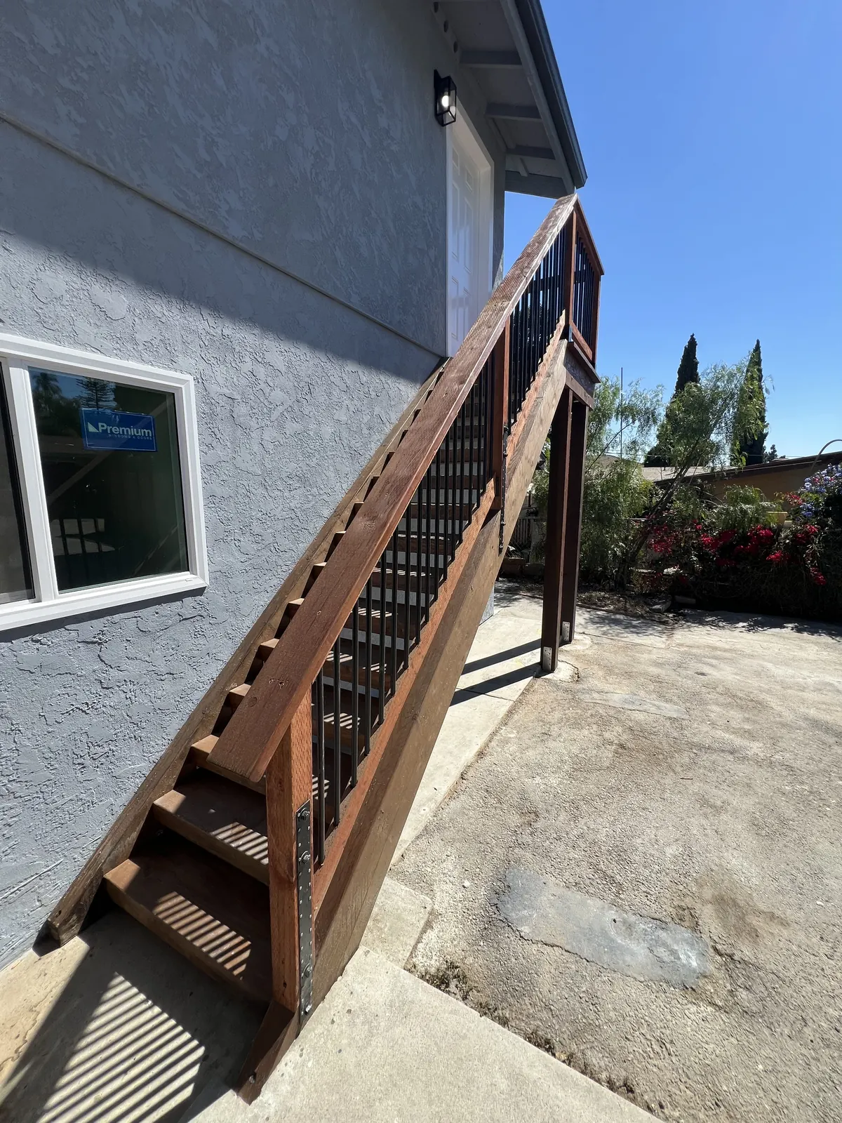 Exterior wooden staircase with a new railing along the side of the rebuilt house