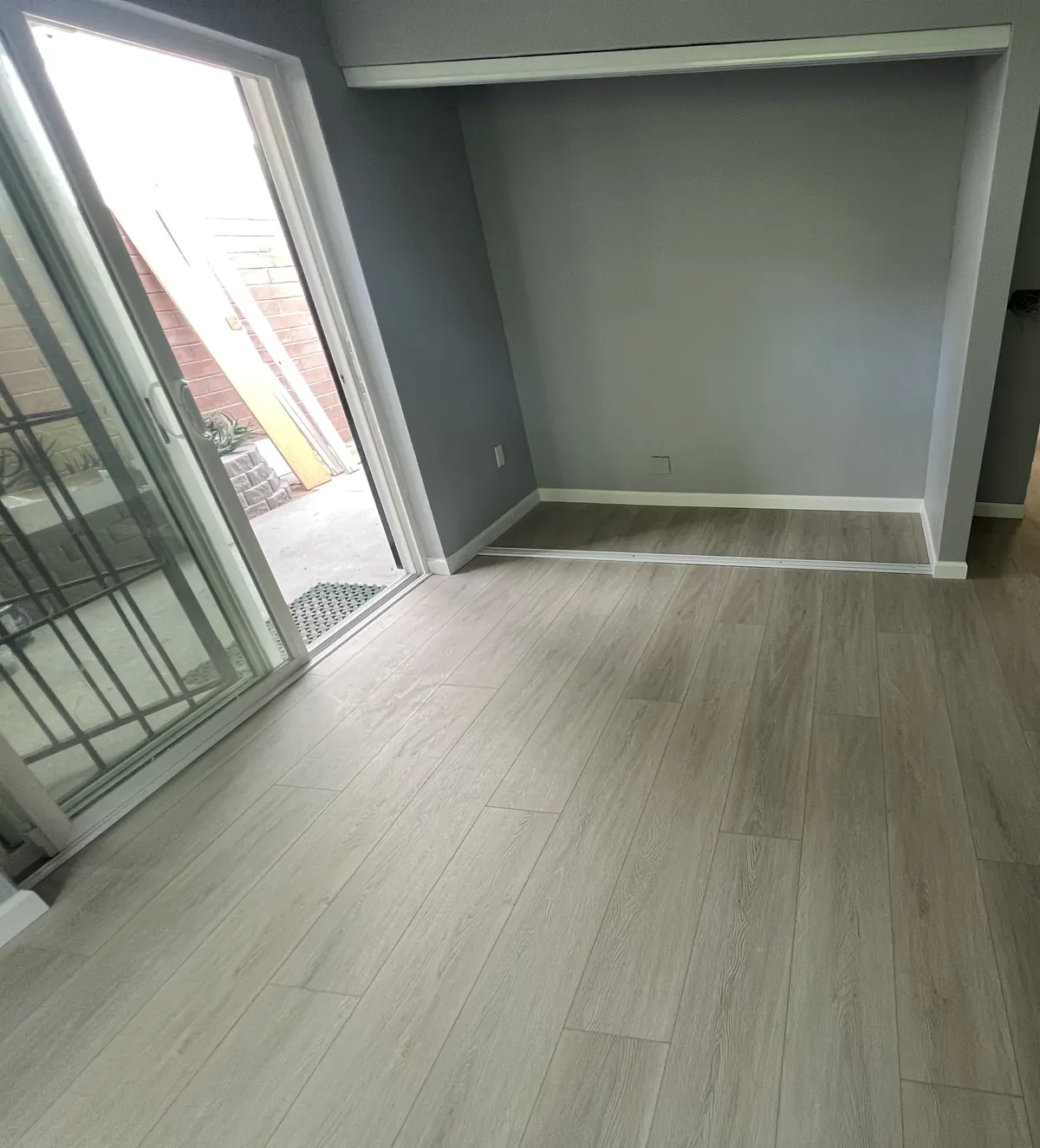 Room finished with gray wood-look vinyl plank and fresh gray walls
