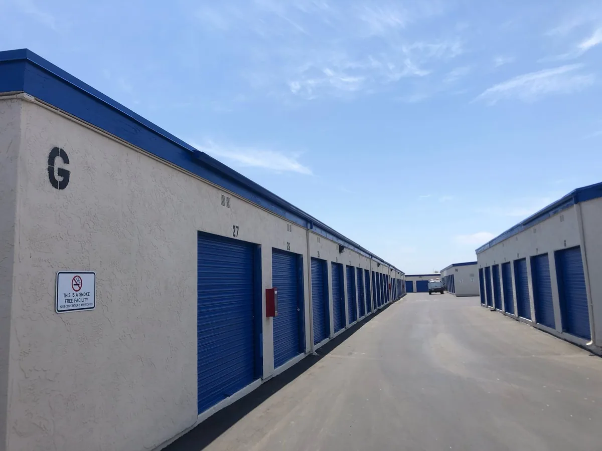 Row of beige stucco storage units with blue doors, completed as a commercial project in San Diego